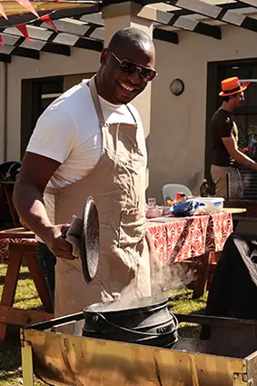 Employee smiling behind barbecue